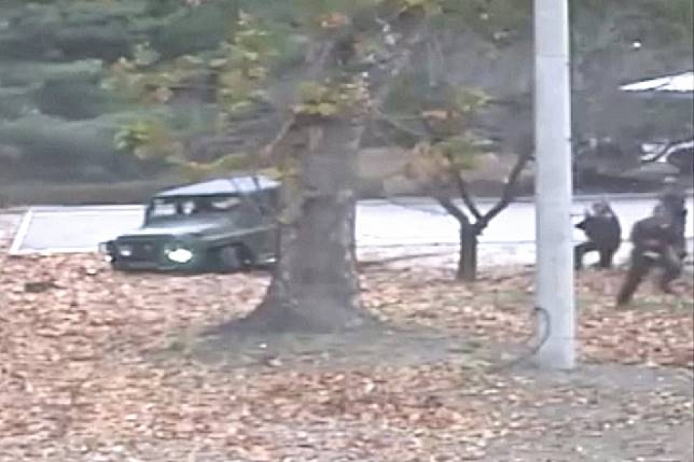 吳姓士兵逃出軍車，後方有北韓士兵追捕的畫面。（美聯社）