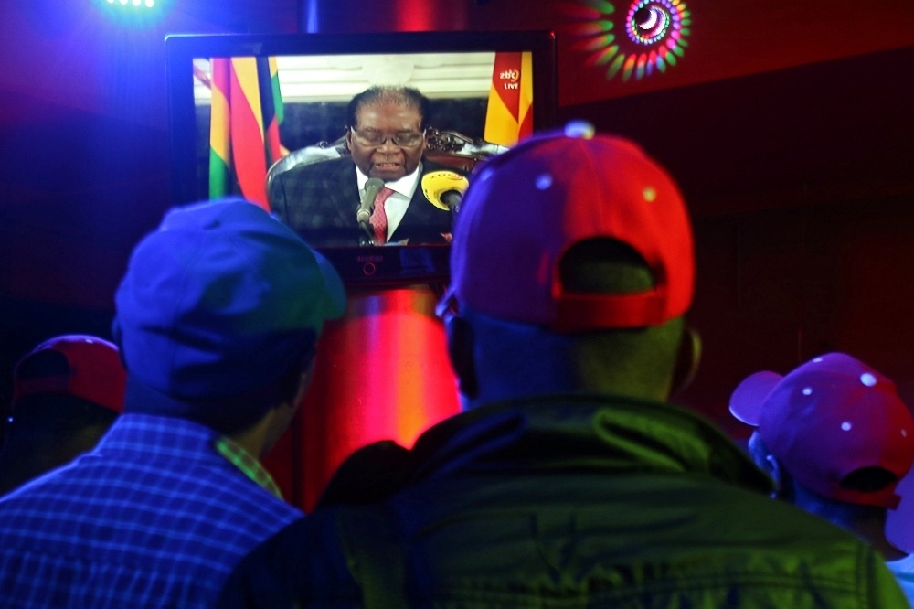 民眾觀看總統穆加比的電視演說。（湯森路透）