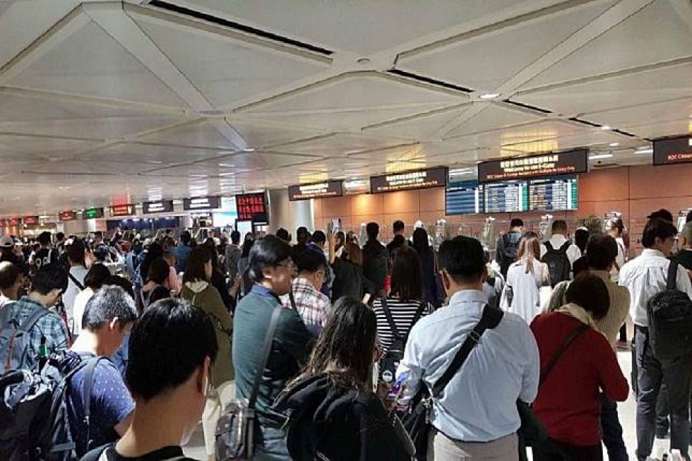 桃園機場出入境證照查驗系統17日下午突然當機，民眾只能在通關處前排隊等候。（圖片取自爆料公社）