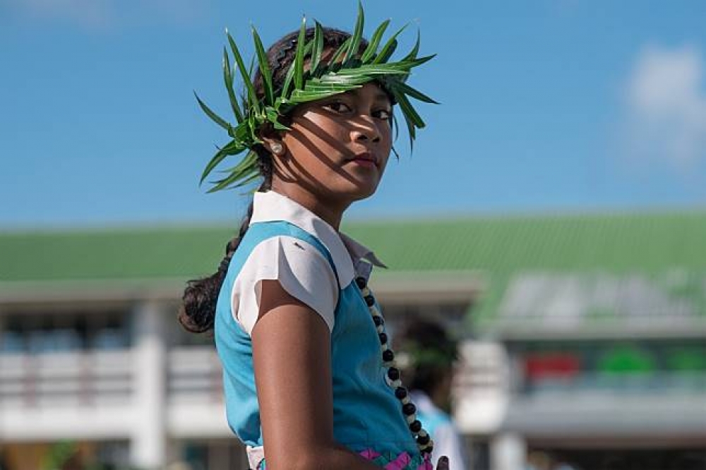 吐瓦魯Nauti小學，頭戴傳統花飾的學童，光影在她臉上劃出好看的陰影線條。（總統府提供）