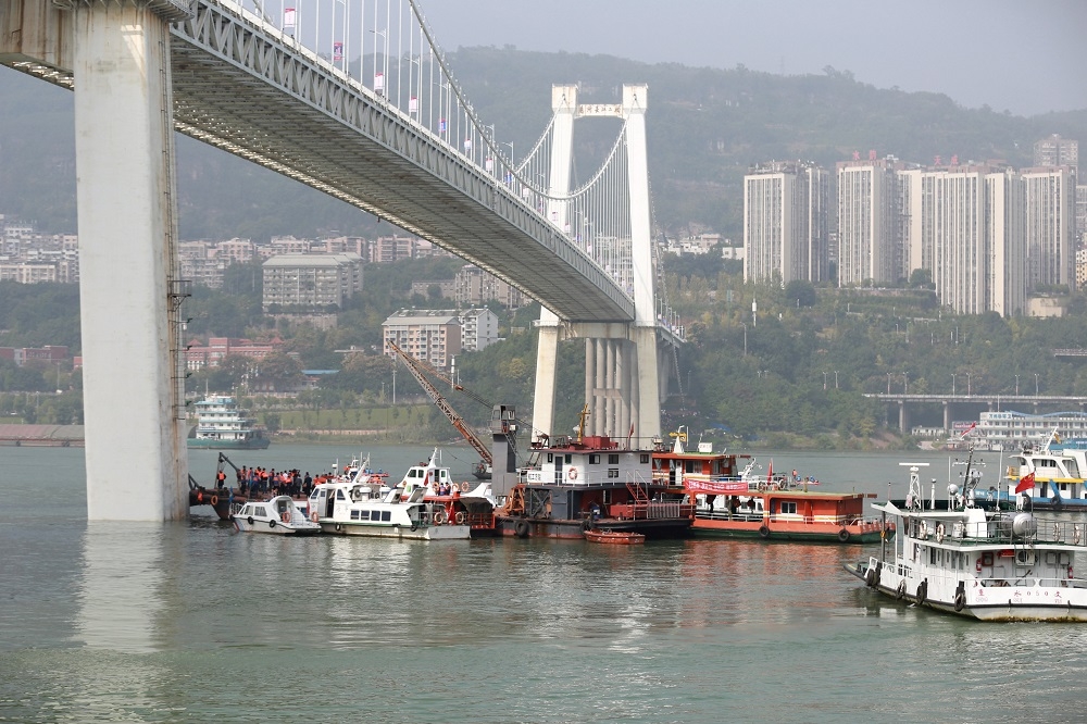中國重慶萬州區長江二橋28日發生嚴重車禍，一輛公車與另一輛對向小轎車相撞後墜入水中。（湯森路透）