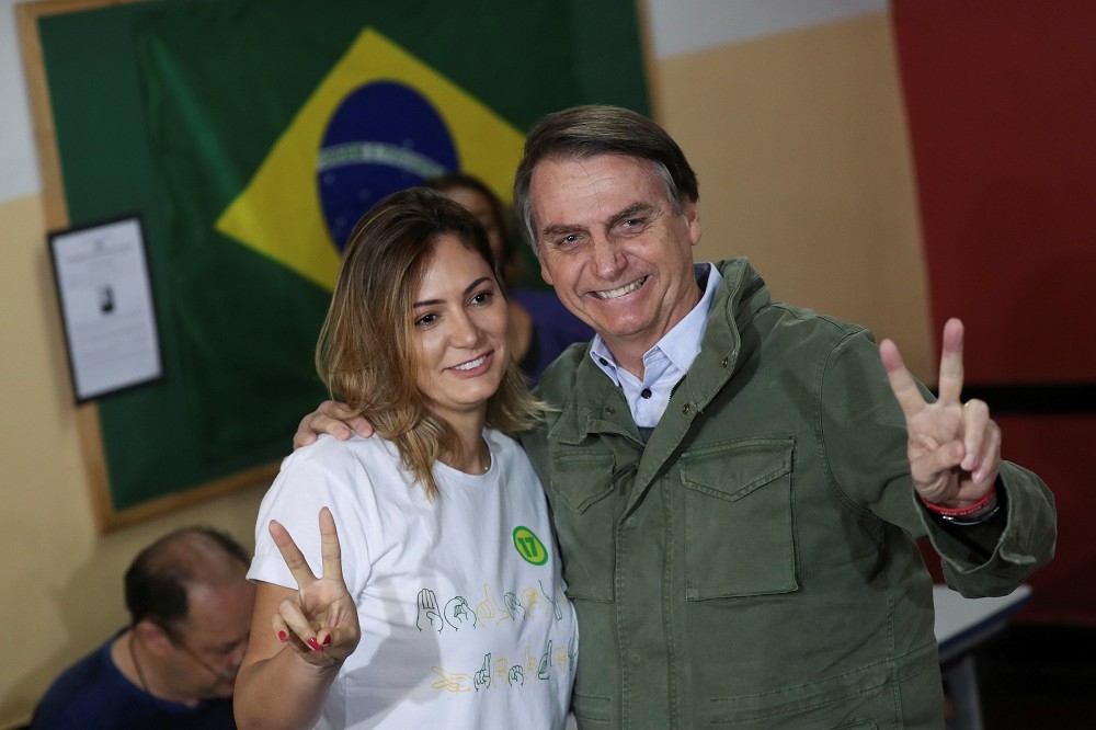 巴西右翼總統當選人波索納洛（右）與支持者合影。（湯森路透）