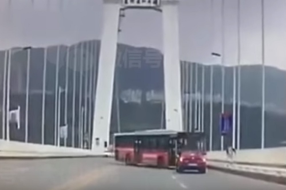 28日上午10時8分，中國重慶一輛公車逆向衝撞小客車後墜江。（取自影片）