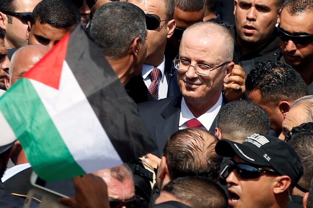哈姆達拉進入加薩地區，身前飄揚一只巴勒斯坦國旗。（湯森路透）