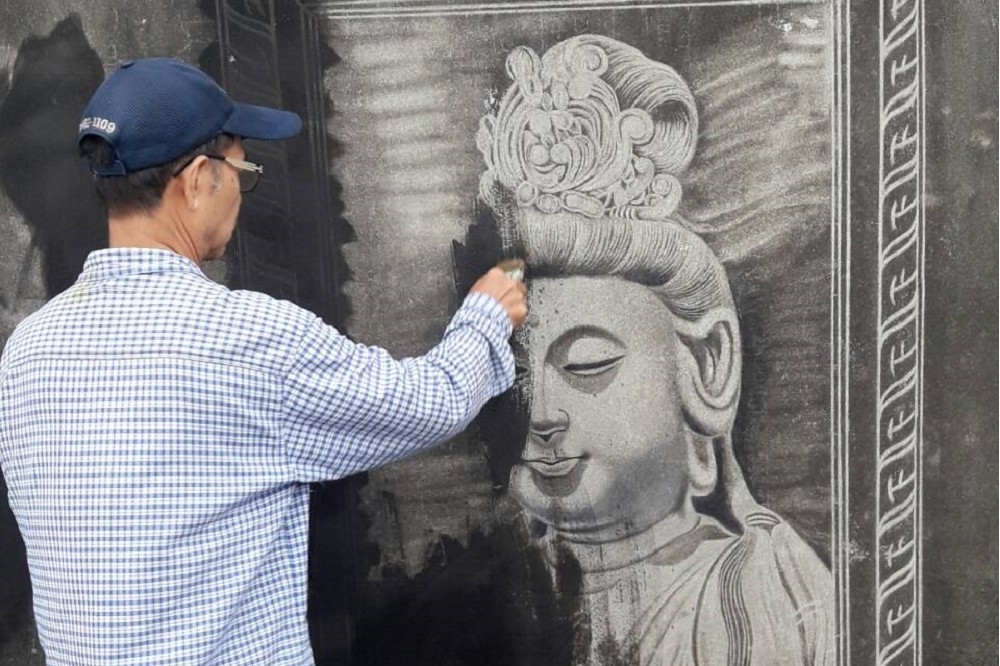 台灣首位鐵刷畫家黃聖人，在屏東工業區一處鍊條工廠的外牆上作畫。由於未經同意，廠方強硬要求黃聖人將所有畫作清除。（黃聖人提供）