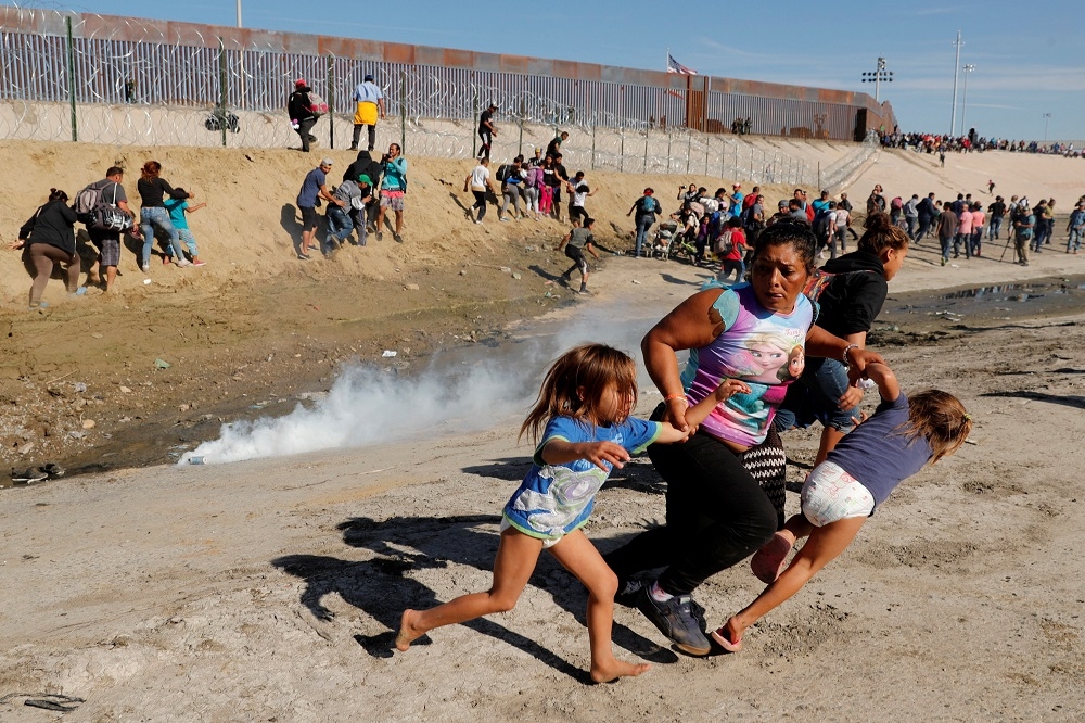 中美洲移民大隊25日抵達美墨邊界的提華納市（Tijuana），試圖闖入美國尋求庇護，但遭催淚瓦斯壓制。（湯森路透）