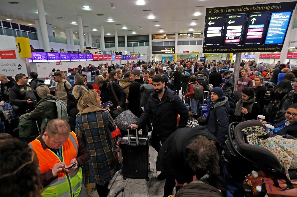 因無人機干擾，20日旅客在英國倫敦第二繁忙機場蓋威克機場等待。（湯森路透）