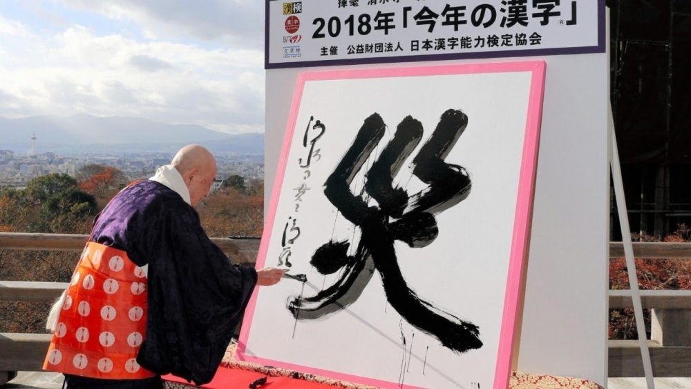 日本漢字能力檢定協會在京都市的清水寺，公布2018年日本年度漢字為「災」。（取自The Japan Times YouTube）