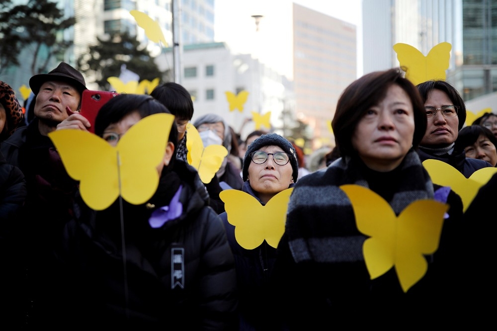 南韓首爾，2月1日民眾手持金色蝴蝶紙悼念金福童。（湯森路透）