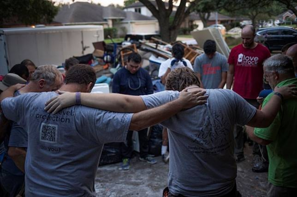 美國宗教團體在德州災區圍圈祈禱。（湯森路透）