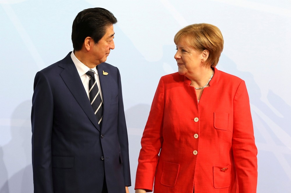 德國總理梅克爾（右）4日訪問日本。（湯森路透）