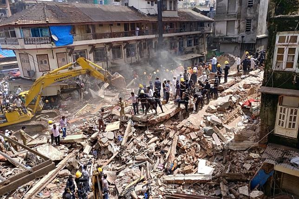 消防員與搜救隊員31日於印度孟買大樓倒塌處搜尋生還者。（湯森路透）
