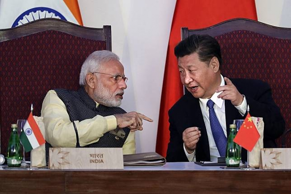 印度總理莫迪（左）與中國領導人習近平（右）2016年出席金磚峰會資料照。（美聯社）