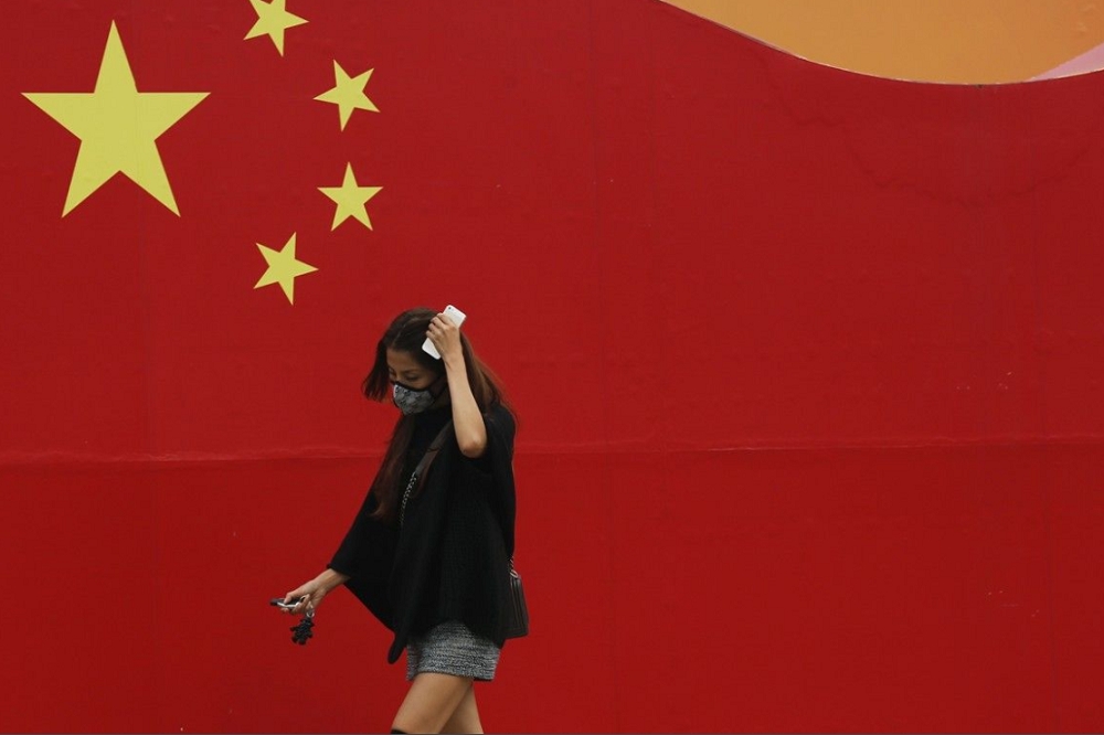 一名女性走過中國國旗的牆。（取自推特@psb_dc）