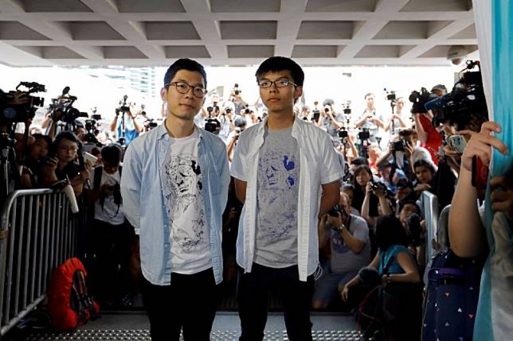 香港眾志主席羅冠聰（左）和秘書長黃之鋒（右）。（湯森路透）
