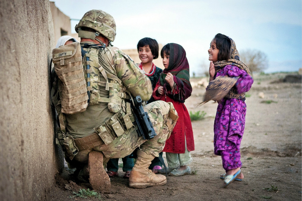 駐紮阿富汗的美國士官與當地小女孩互動。（圖片取自美國陸軍）