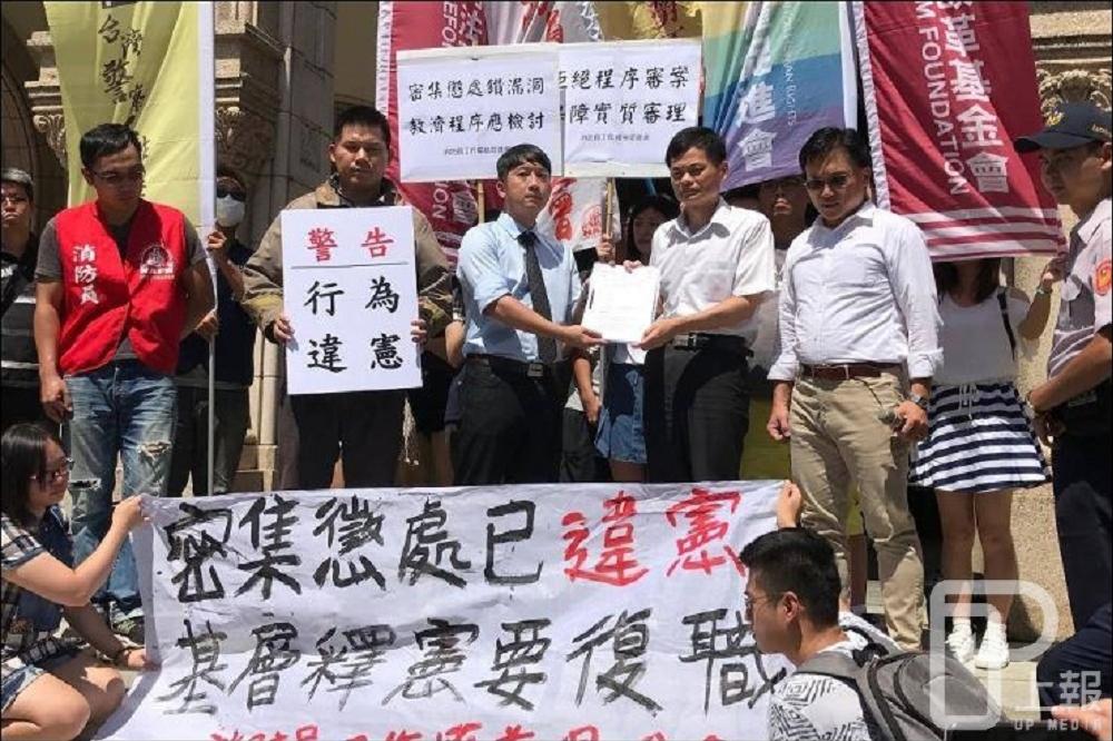 因不滿被免職，高雄市前消防員徐國堯（左2）9日在相關單位與律師陪同下，到司法院陳情並提釋憲陳情書。（攝影：盧禮賓）