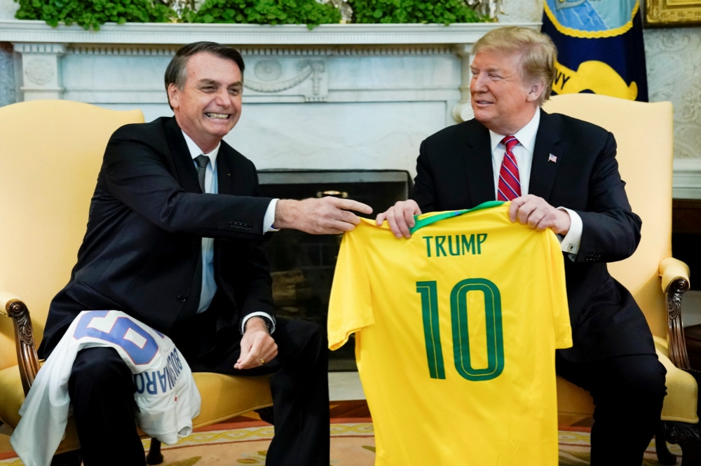 出訪華府的巴西總統波索納洛（圖左），在白宮與川普（圖右）互贈國家隊球衣。（湯森路透）