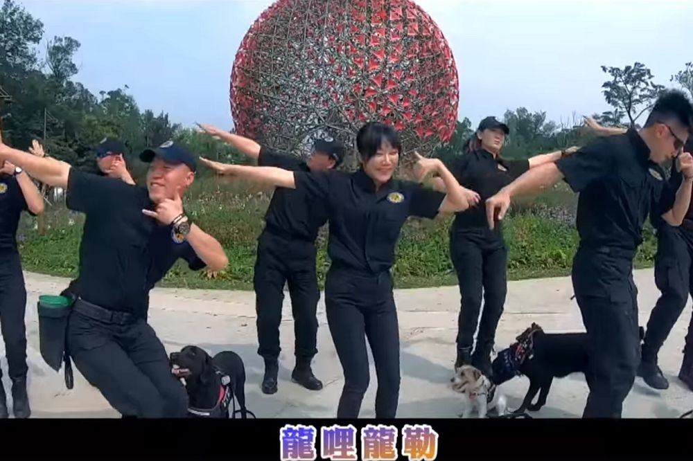 台中市警察局警犬隊慶祝警犬隊成立滿1周年，推出紀念影片，其中由正妹警犬隊長（中）帶領其他領犬員及8隻警犬，熱舞並歡唱Rap，讓網友直呼「好可愛」。（圖片截取自TCPB局長室臉書影片）