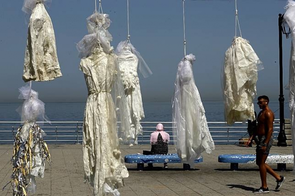 人權團體「Abaad」4月將逾30件雪白婚紗垂掛於棕櫚樹上，抗議黎巴嫩用婚姻特赦性侵犯。（湯森路透）