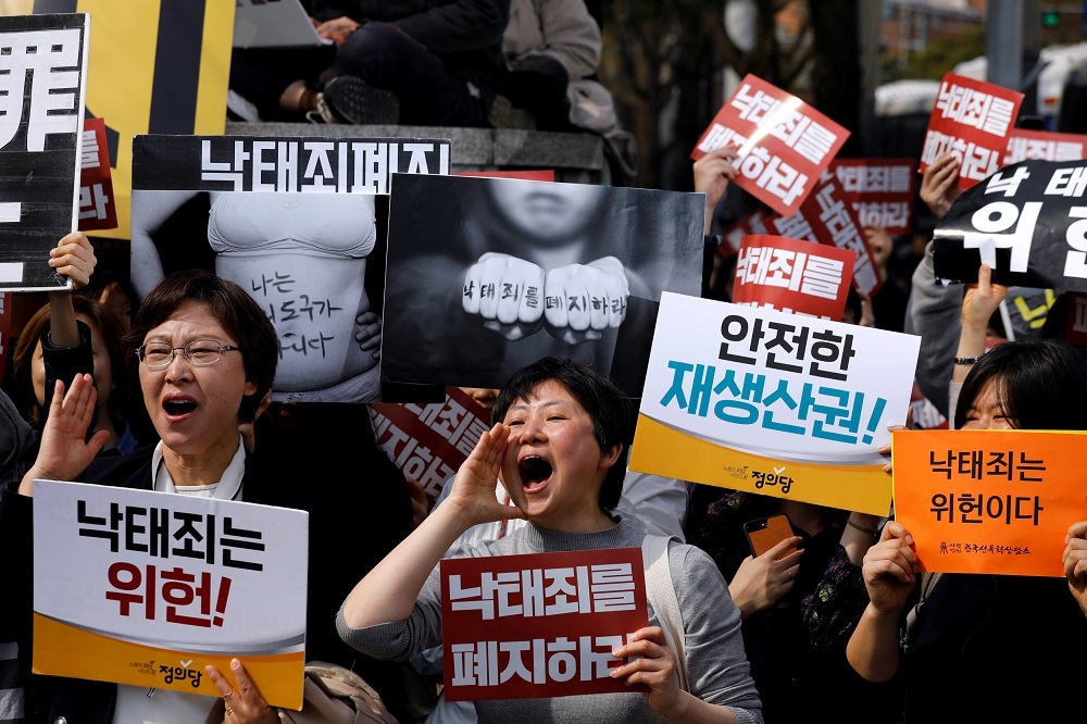 支持廢除墮胎罪的南韓民眾舉牌表達意見。（湯森路透）