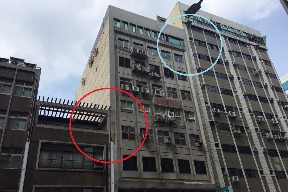 長安東路二段大樓因地震傾斜，紅圈表示大樓裂痕，藍圈表示中間大樓向右傾斜，與隔壁大樓「黏」在一起。（攝影：黃雅旋）