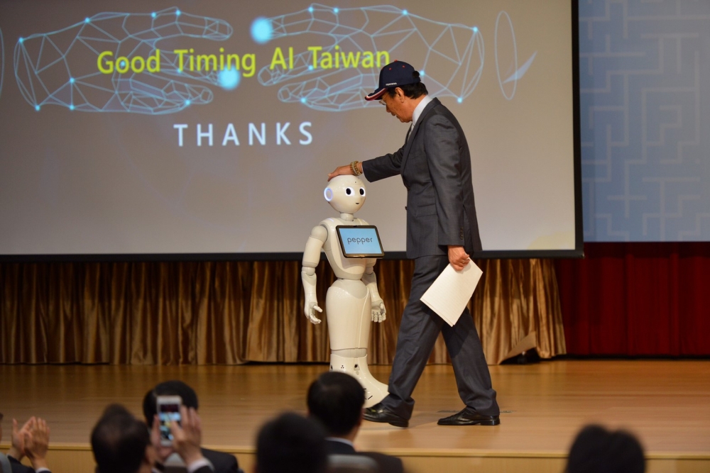 聽到自家AI說「2020郭台銘，AI台灣；2020郭台銘，愛台灣」後，郭台銘輕拍AI的頭喊「不錯！」（攝影：李智為）