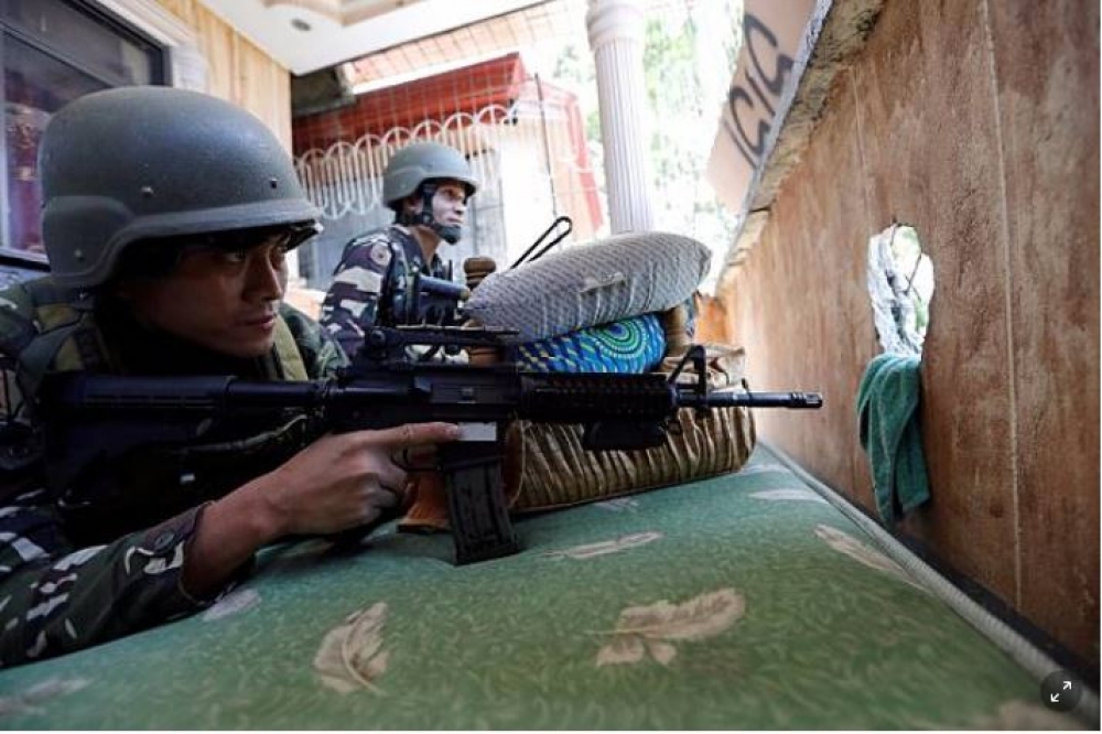 菲律賓士兵臥倒在陽台上，準備攻擊武裝分子。（湯森路透）