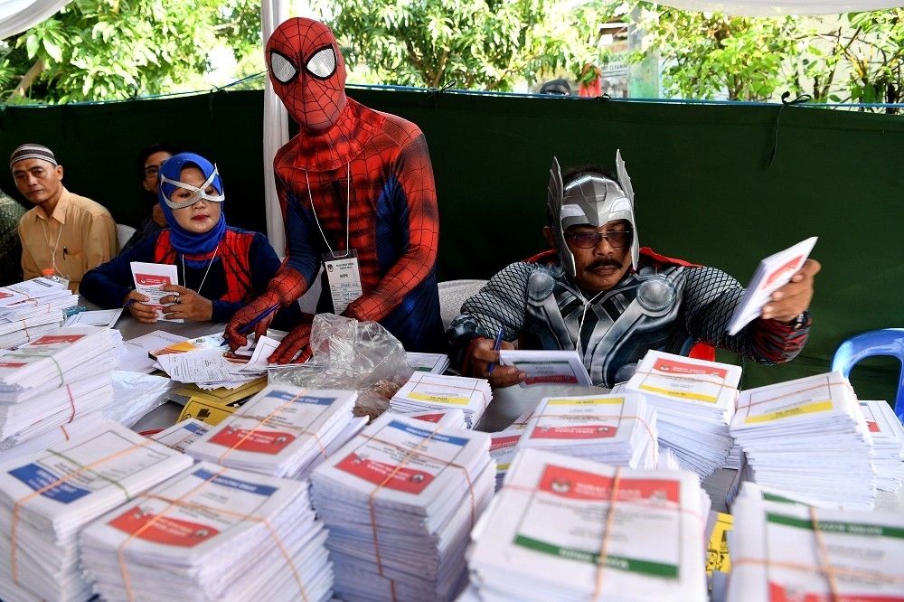 印尼這次大選，並沒有在八小時開完票，這部分是丁守中誤解之處。（選務人員穿著超級英雄裝準備選票／湯森路透）