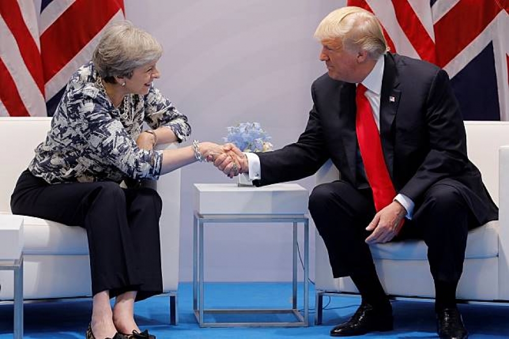 英國首相梅伊（左）與美國總統川普（右）8日於漢堡的G20峰會中。（湯森路透）