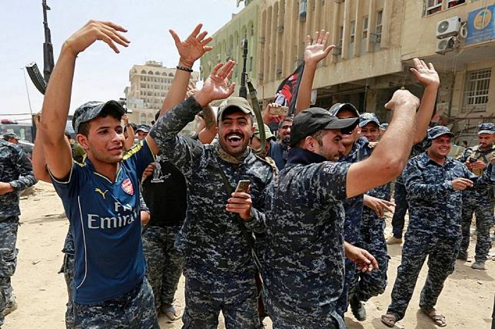 伊拉克部隊慶祝收復摩蘇爾。（湯森路透）