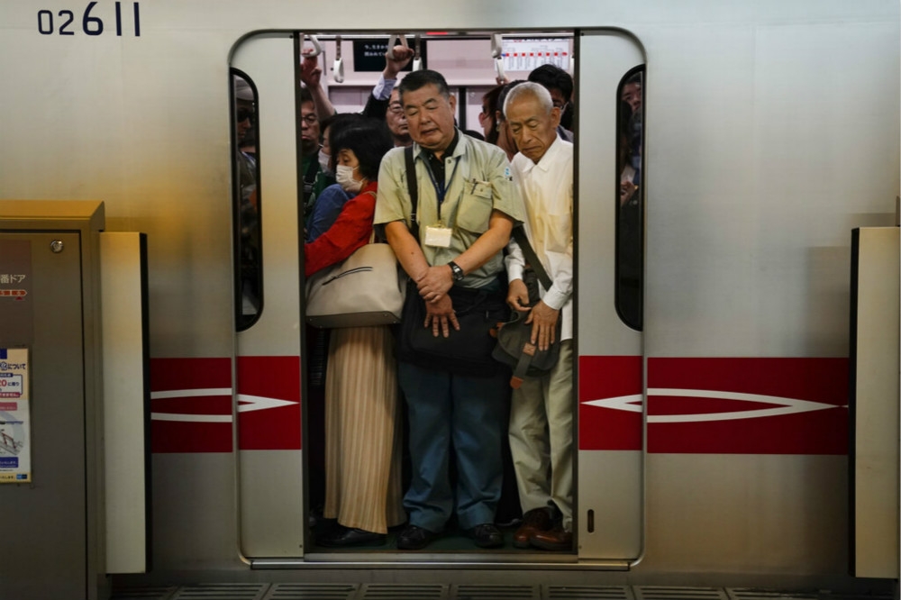 搭乘電車上班的日本民眾。（美聯社）