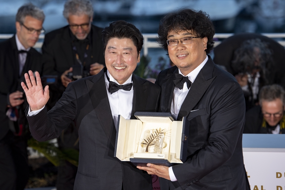 韓國導演奉俊昊（右）以《寄生上流》拿下今年坎城影展的金棕櫚獎，左為演員宋康昊（湯森路透）