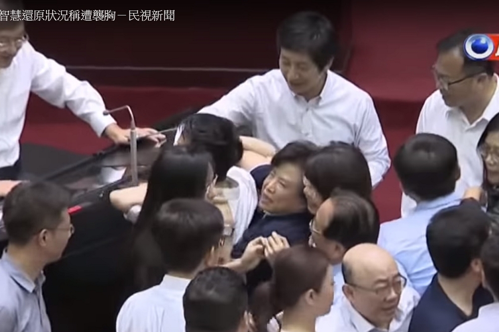 藍綠立委28日在立院爆發衝突，何志偉(左)和沈智慧(右)因一張「環抱照」，讓雙方再度交火。(圖片截取自民視新聞Youtube)