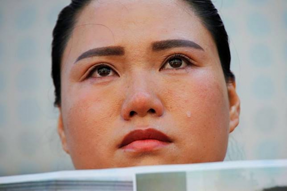 維權律師勾洪國因「709大捉捕」入獄後被釋放，其妻子樊麗麗7日到北京中國最高人民法院舉牌抗議。（湯森路透）