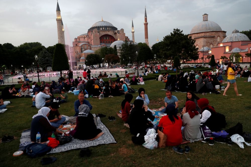 清真寺前許多人席地而坐。（湯森路透）