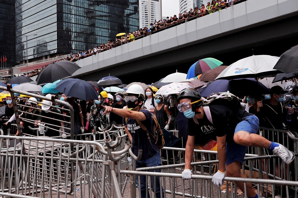 香港民眾臉戴護具防範警方以任何手段驅趕。（湯森路透）