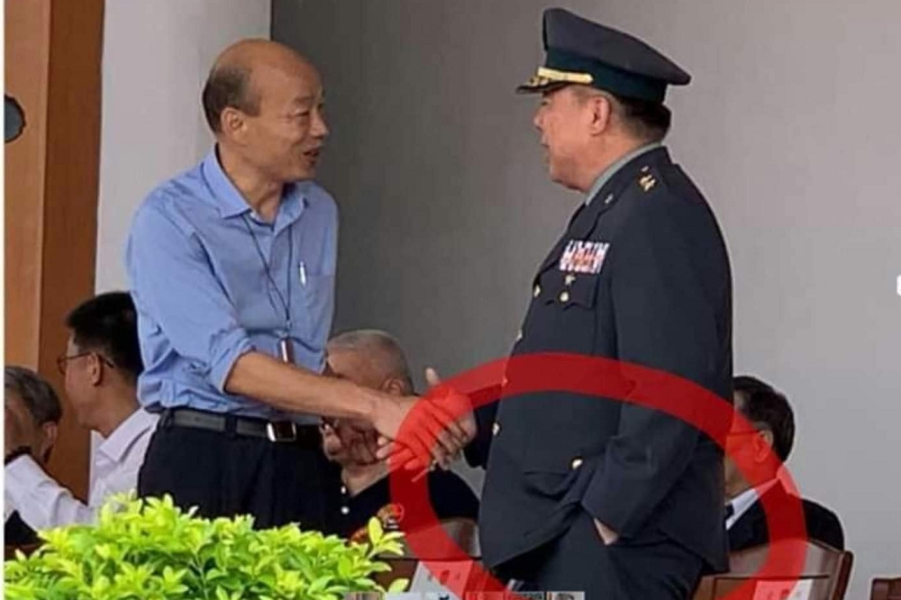 網友po出徐衍璞中將與韓國瑜握手時手插口袋的照片，引發熱議。（圖片取自網友回覆）