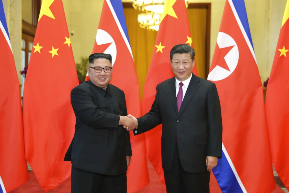 北韓領導人金正恩（左）出訪北京會見習近平（右）。（美聯社）
