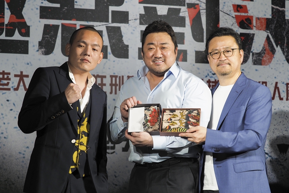 玖壹壹團長春風（左一）代表電影公司致贈刺青袖套給《極惡對決》主演馬東石（中）和導演李元泰（右）作為禮物（攝影：張家銘）