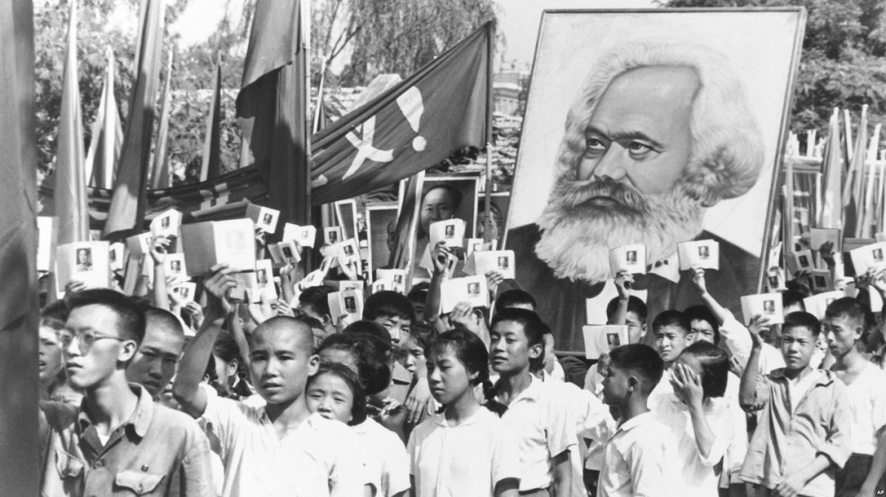文革初期，青年揮舞毛主席語錄，抬著馬克思像遊行。（圖片取自香港立場新聞）