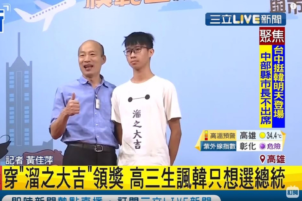 高雄市長韓國瑜21日出席鳳山場市長獎畢業生合影活動，又被穿「溜之大吉」T恤的學生突襲，雙方僅合影無其他互動。（取自三立新聞YouTube）