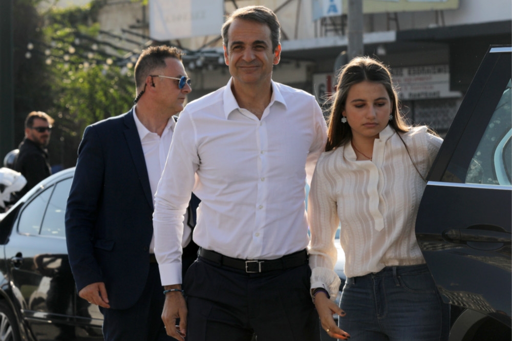 新當選的右派總理米佐塔基斯（中央）和女兒Dafni（右）前往投票。（湯森路透）