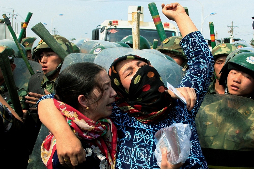 新疆地區少數民族婦女遭到中國武警包圍。（湯森路透）