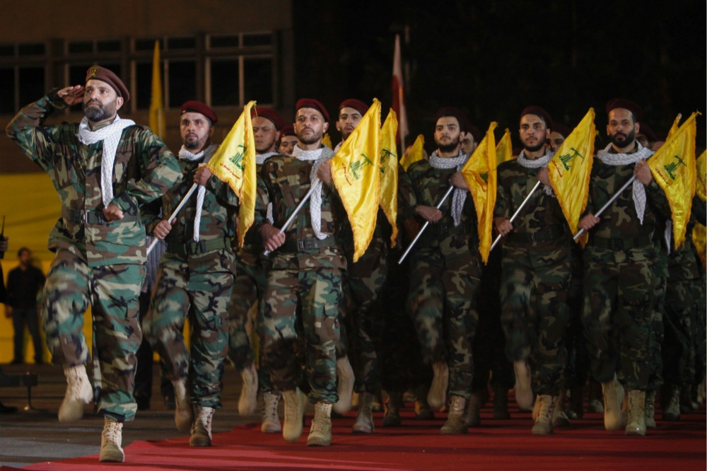 黎巴嫩真主黨成員手持黨旗進行閱兵儀式。（湯森路透）