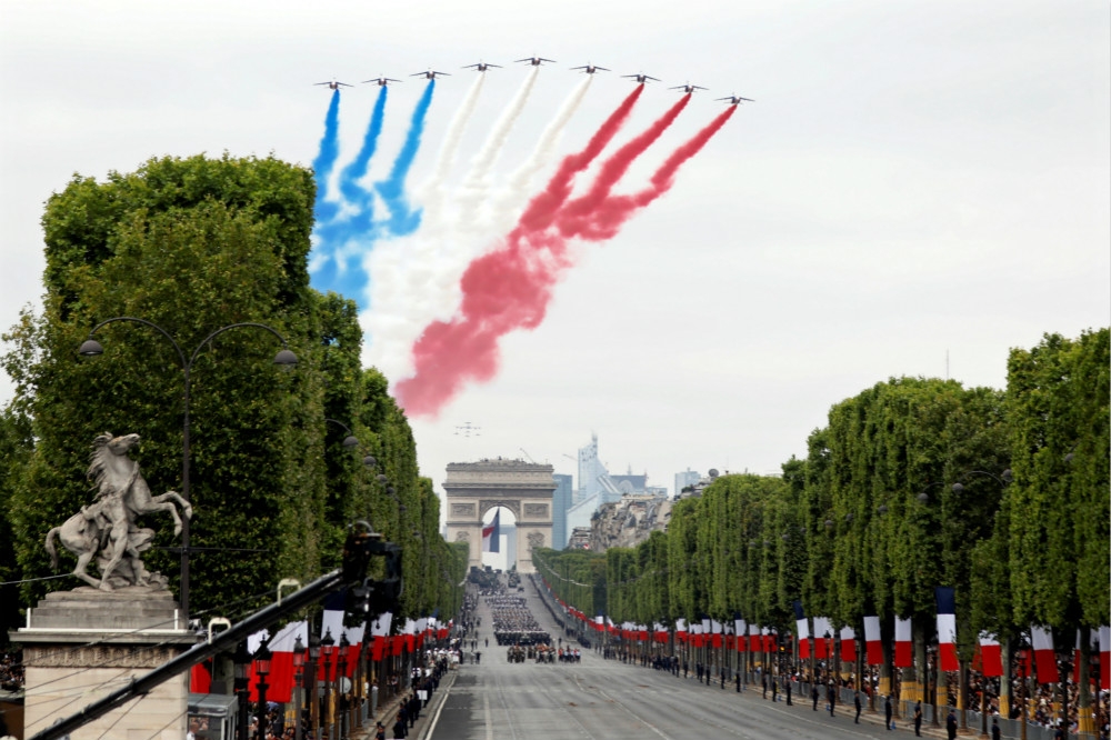 法國空軍表演特技隊在香榭麗舍大道上空噴出藍、白、紅國旗三原色的煙霧。（湯森路透）