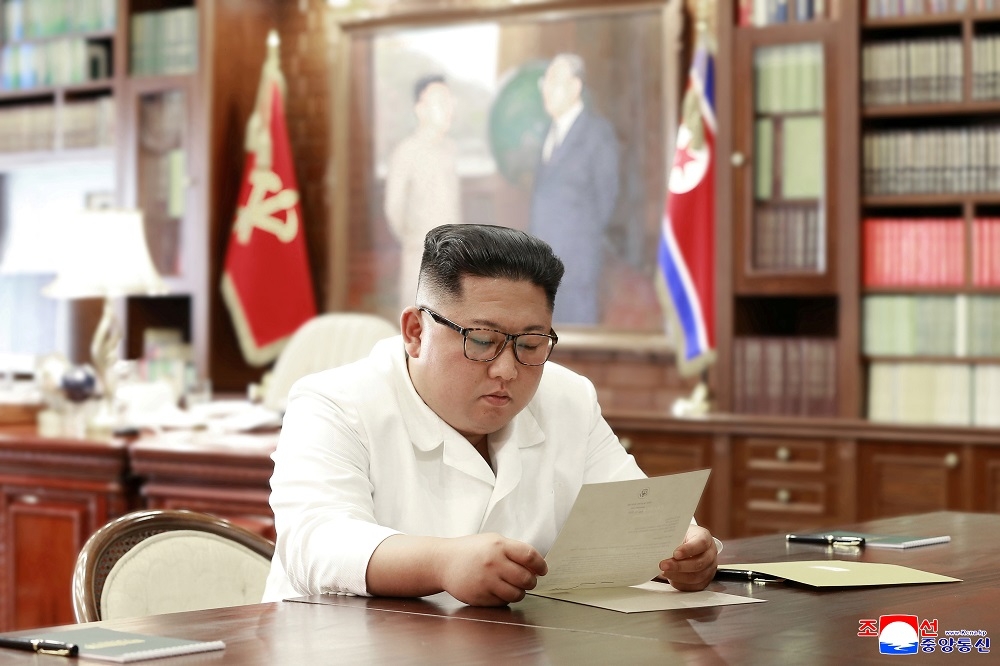 北韓領導人金正恩6月22日閱讀美國總統川普的來信。（湯森路透）