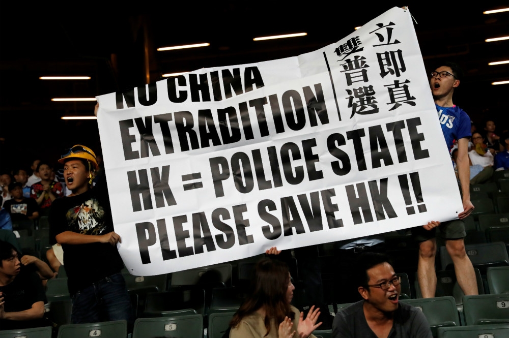 香港示威民眾高舉「要真普選、反送中條例」的布條。（湯森路透）