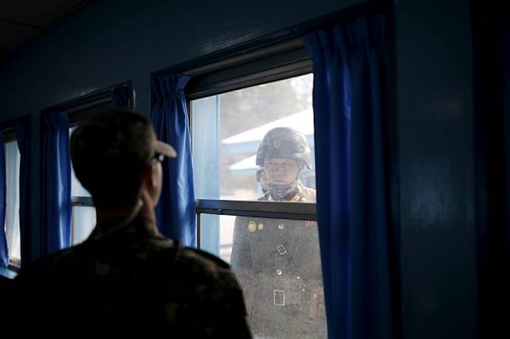 南北韓士兵於板門店建築內外對視。（湯森路透）