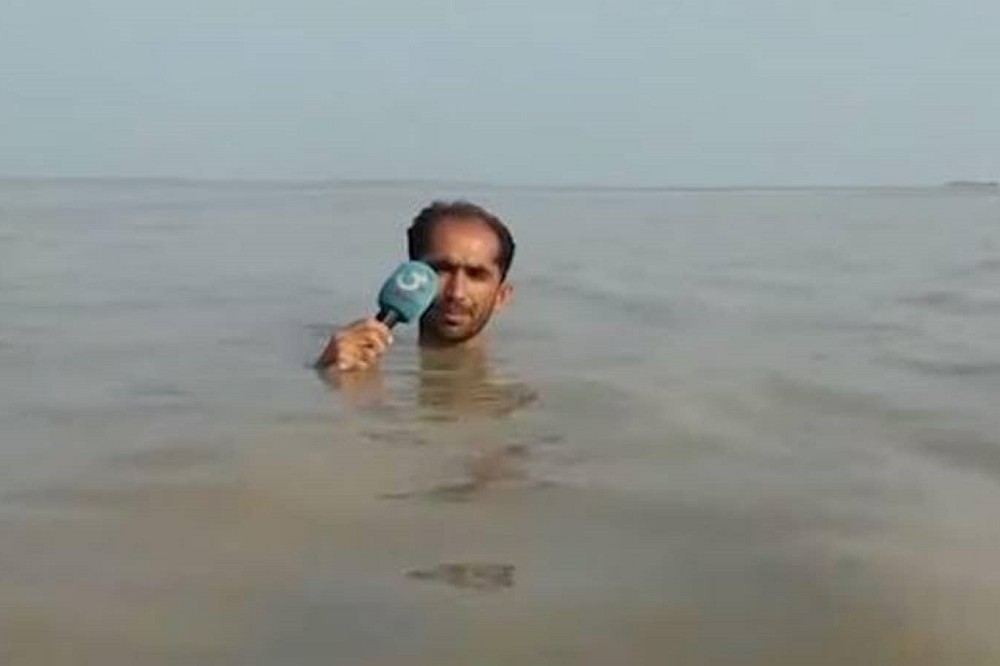 巴基斯坦記者胡森為報導水災，全身浸入洪水之中。（擷取自Youtube）
